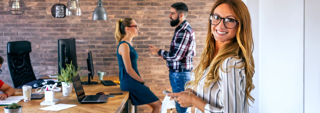 Smiling businesswoman looking at camera in office