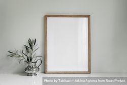 Blank vertical wooden picture frame mockup of olive tree branches in elegant silver jug vase 0yRWW5