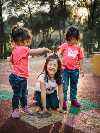 Cheerful girls having fun on playground outdoors