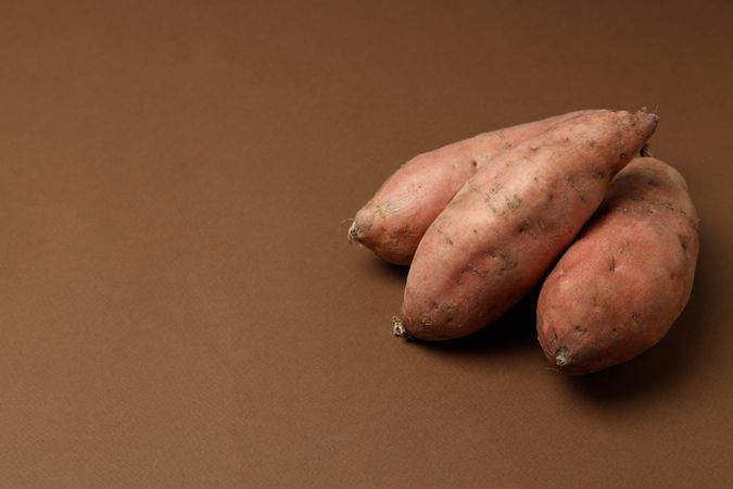 Fresh sweet potato on a brown background