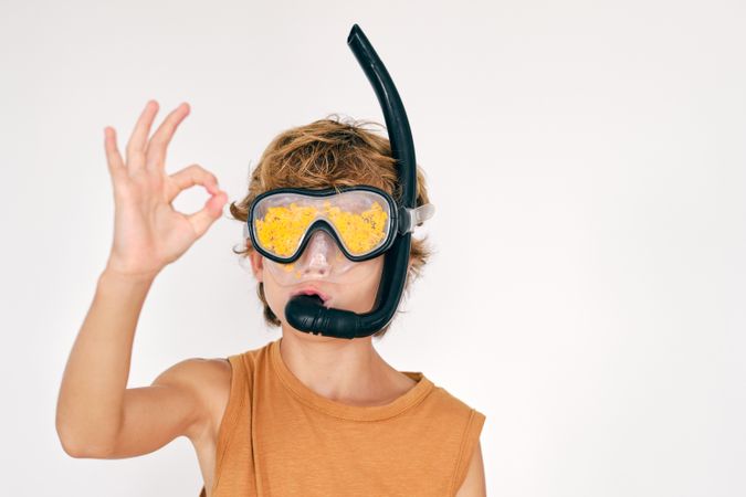 Boy in snorkeling goggles showing OK gesture