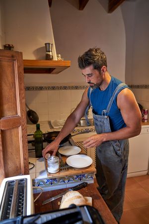 Focused man preparing breakfast at kitchen