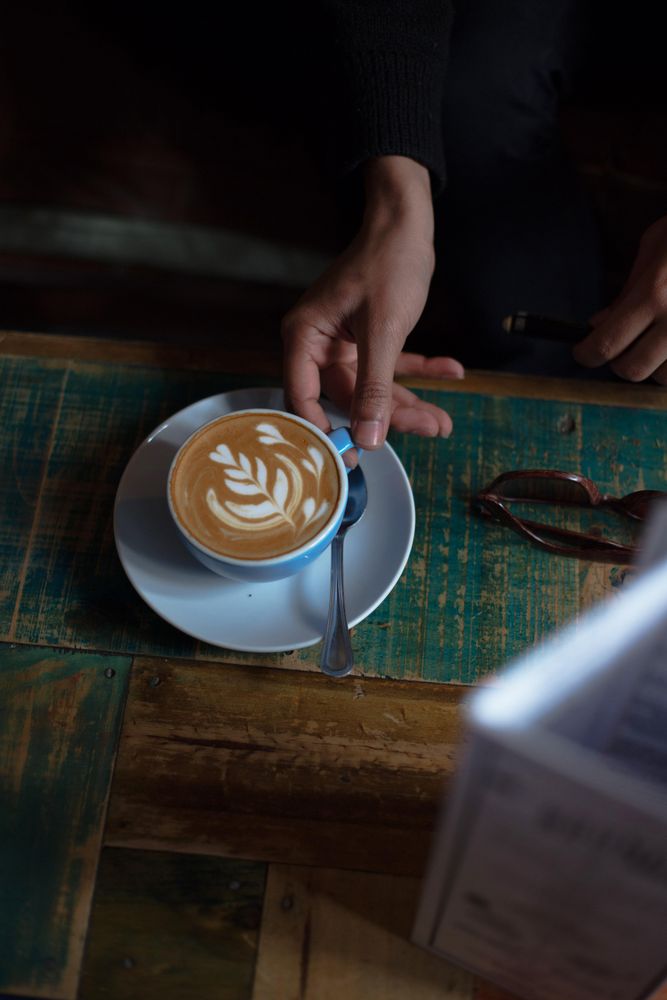Hand on saucer of coffee cup