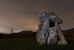 Ancient dolmen against night sky