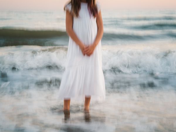 blur girl standing on seaside among waves