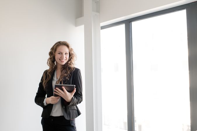 Smiling woman using tablet in office