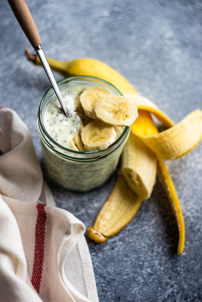Healthy breakfast with chia seeds and banana slices on counter with copy space
