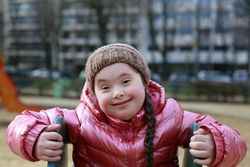 Happy child climbing up slide on playground