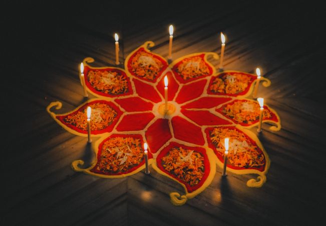 Lit candles on flower shaped carving on floor