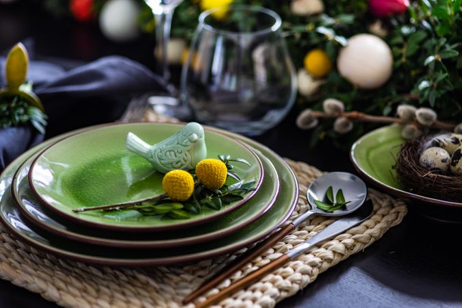 Elegant green plates on placemat for spring themed table
