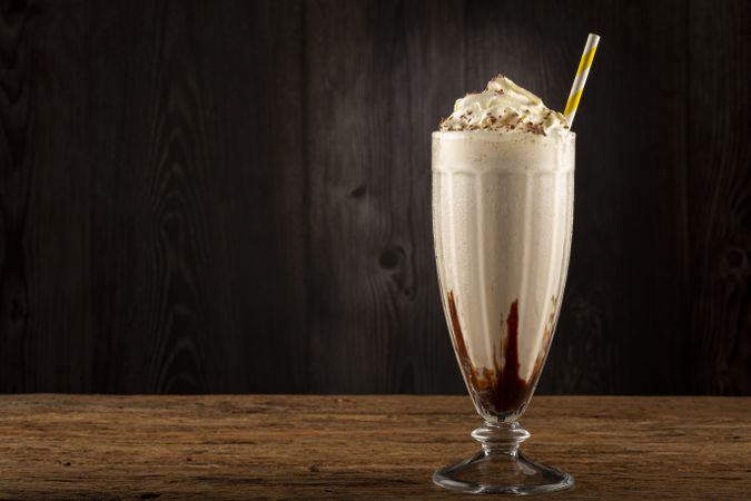 Vanilla milkeshake with whipped cream and chocolate sauce.