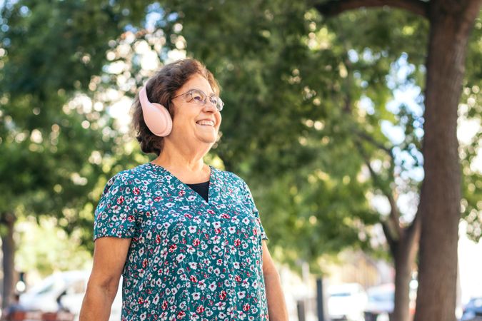 Mature woman walking down the street listening to music