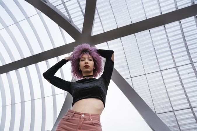 Stylish woman with pink hair looking at camera
