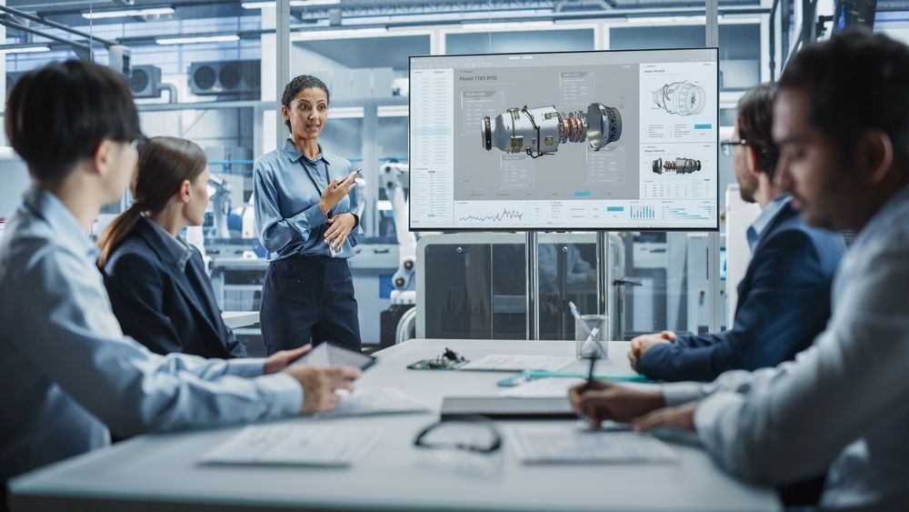 Group of designers in meeting room with screen