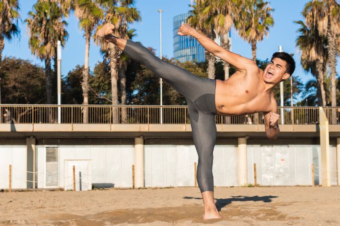 Energetic sportsman doing kick on street