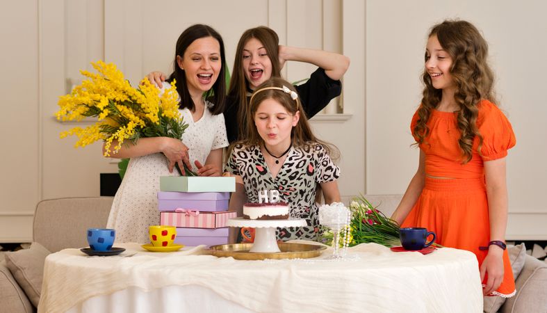 Group of children celebrating birthday party with cake.