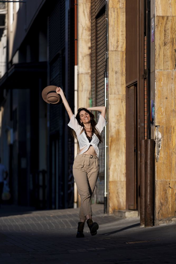 Carefree young woman walking in casual wear in the street