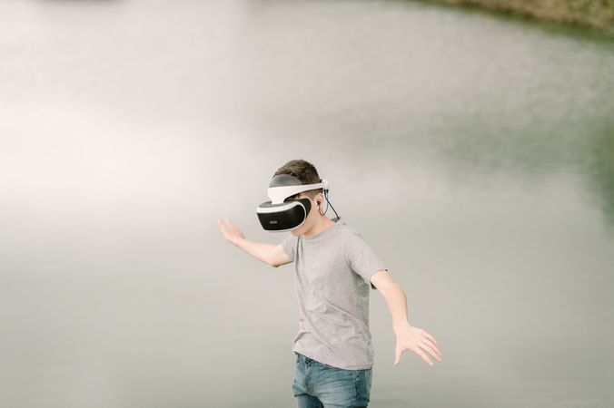 Young teenager with virtual reality glasses outdoors