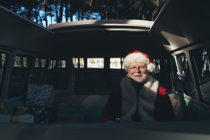 Cheerful Santa Claus sitting in van