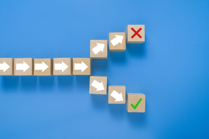 arrow symbol on wooden blocks splitting into right and wrong direction. concept of choosing right or wrong way