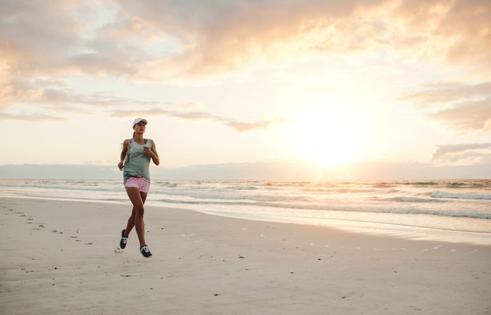 Fit woman running on the beach in morning