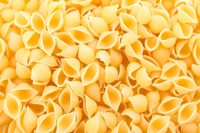 Pasta as background, closeup. Uncooked whole wheat pasta