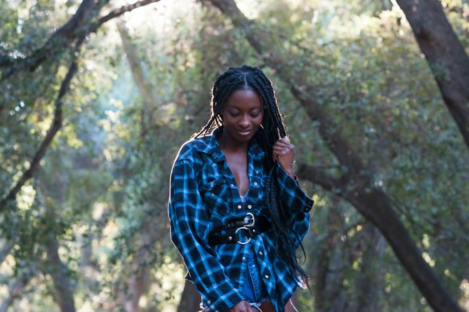 Portrait of Black woman with box braids standing in the woods