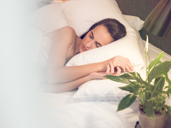 Relaxed woman sleeping on bed