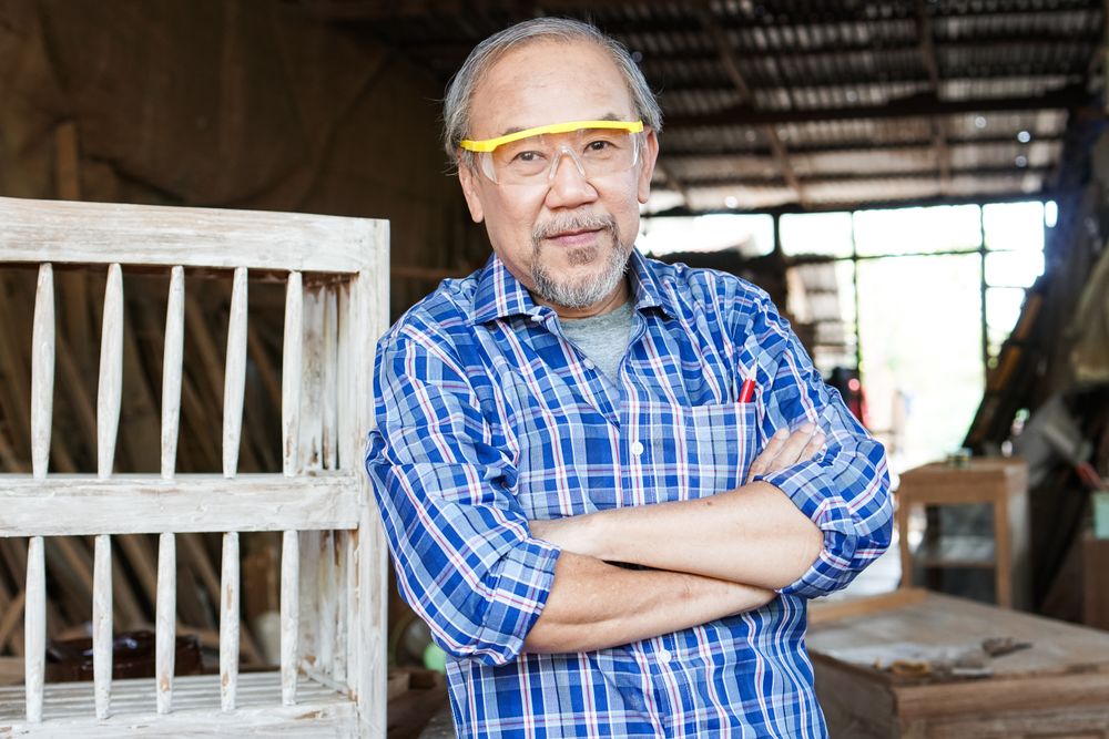 Portrait of Asian carpenter with arms crossed at carpentry workshop