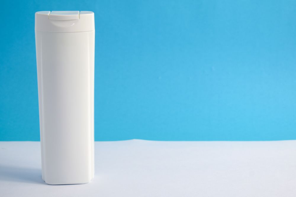 Shampoo bottle with no labels in blue room