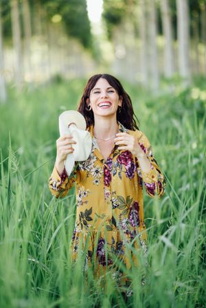 Laughing brunette female looking at camera in field of tall grass