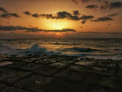 Sea waves crashing on shore during sunset