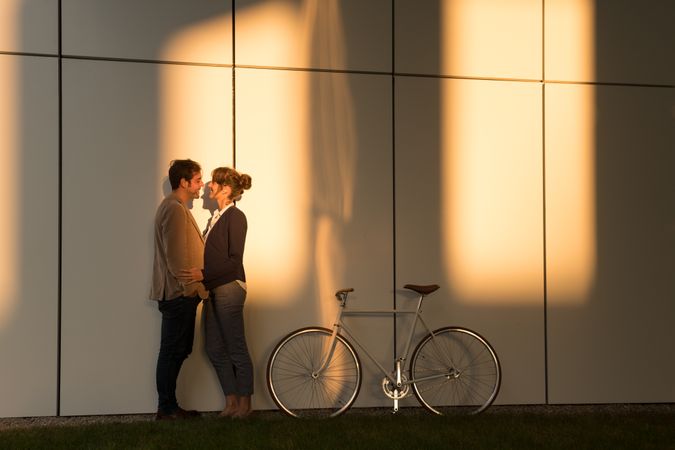 Happy colleagues hugging near bicycle