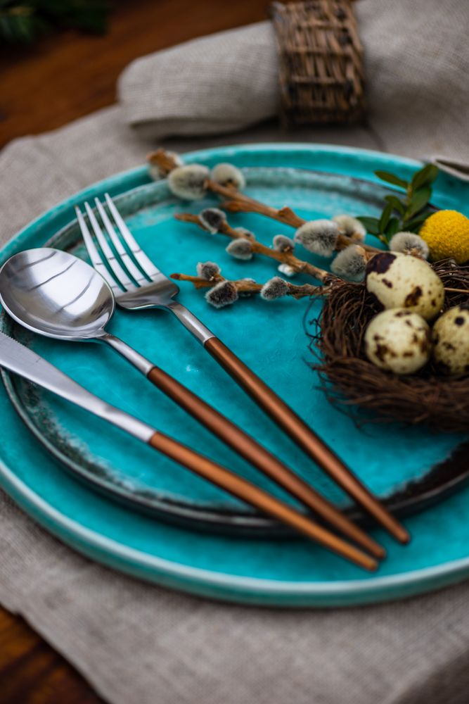 Easter table setting with delicate bird nest on teal plate