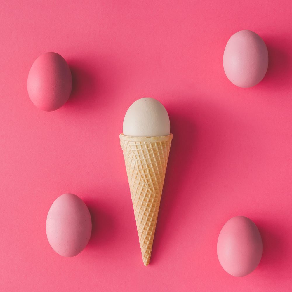 Ice cream cone with eggs on pink background