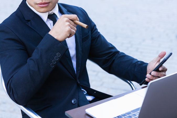 Businessman smoking cigar in street cafe