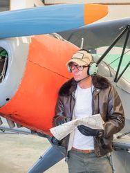 Pilot with map beside small plane