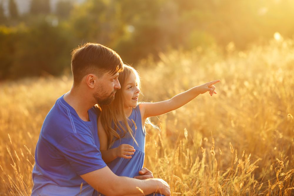 Dad and daughter in field of long grass