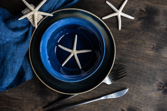 Summer table setting with sea stars and shells on wooden table