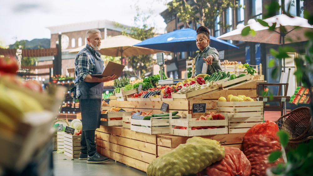 Female and Male Business Partners Managing a Successful Organic Farm Stall at a Farmers Market.