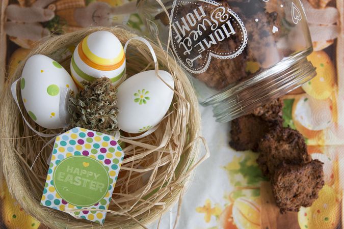 Jar of infused cookies next to a nest of eggs & dried marijuana