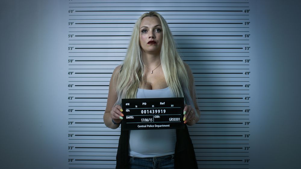 In Police Station Arrested Woman Posing for Front-View Mugshot.
