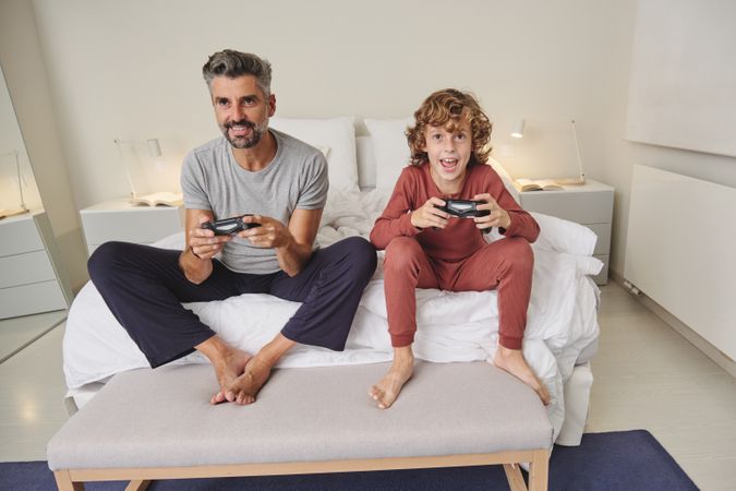 Excited father and son playing videogame