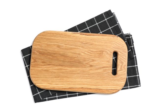 Cutting board with kitchen towel isolated on studio background, top view