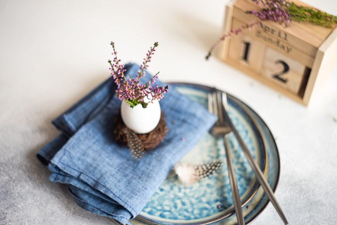 Heather in decorative egg on blue napkin for Easter dinner