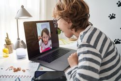 Delighted boy and girl in sunglasses making video chat