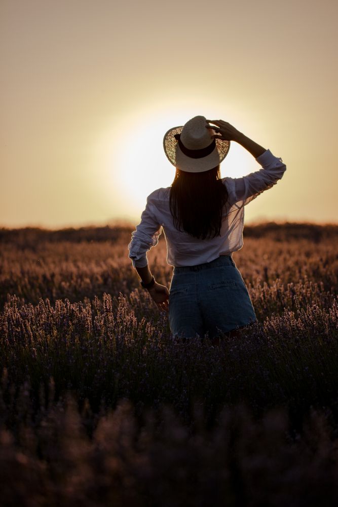 Anonymous woman walking in lavender field