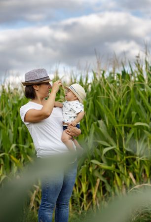 Adorable mother and child on hand enjoying and laughing in field