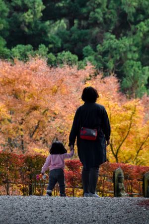 Back view of mother walking her young daughter outdoor in Japan