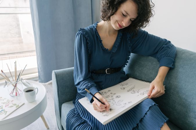 Woman artist drawing at sofa